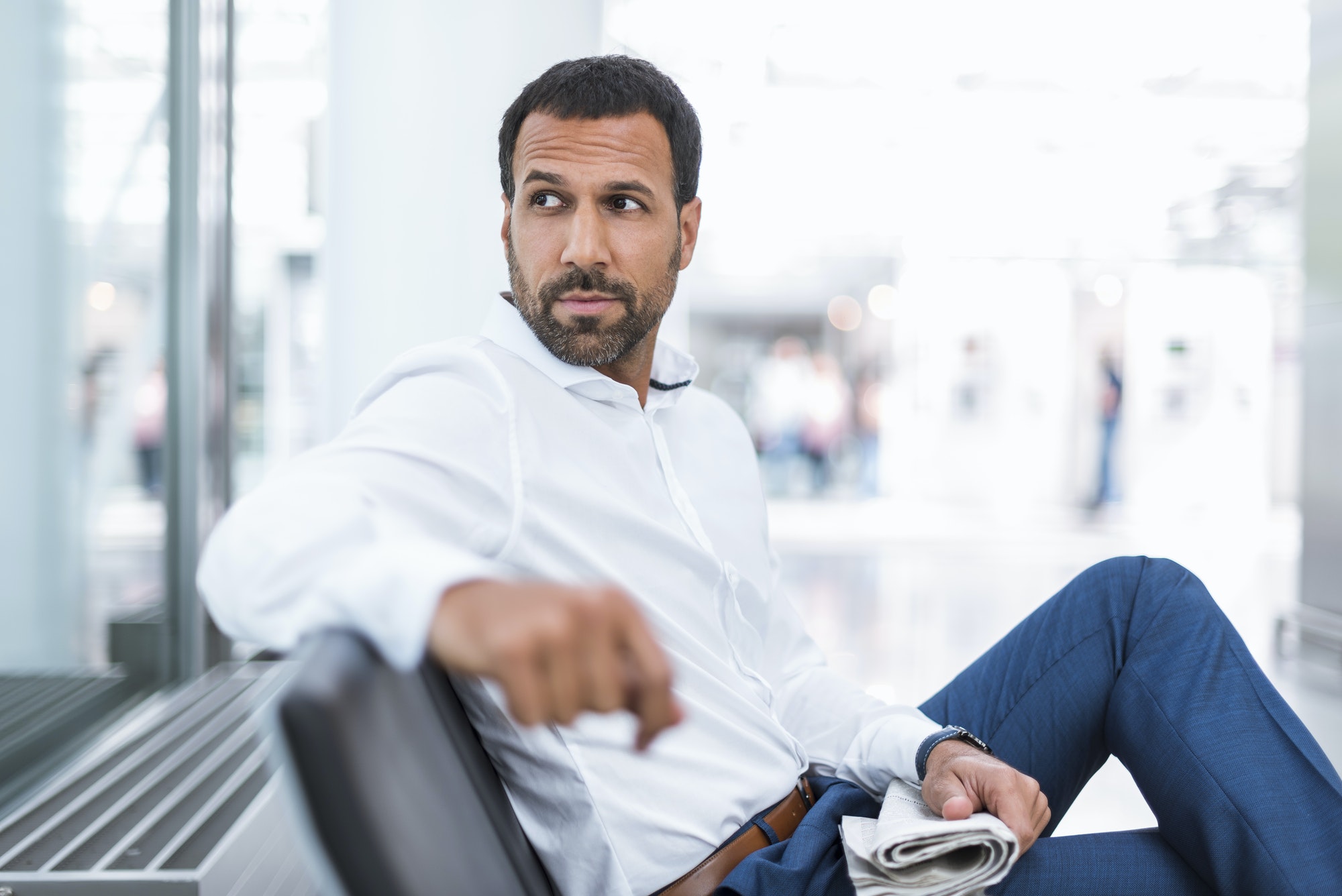 Businessman with a newspaper in waiting hall