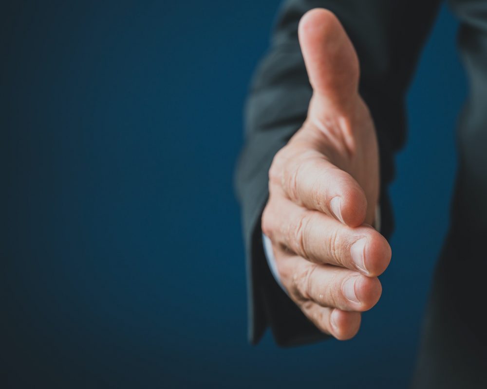 Hand of a businessman reaching in handshake